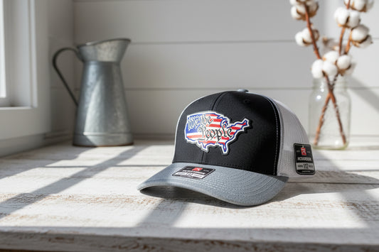 Gray and black cap with 'We the People' design on a white surface