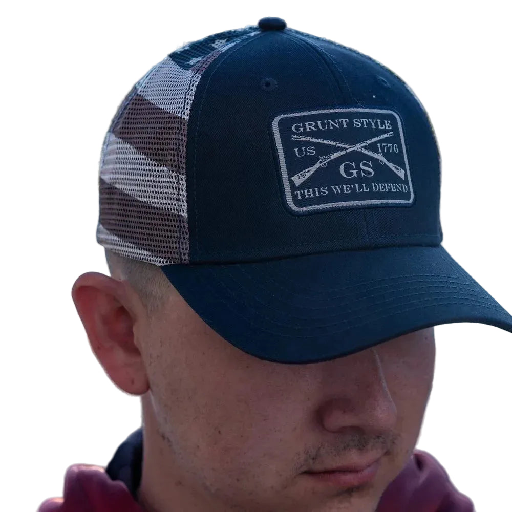 Person wearing a blue cap with a logo and text, outdoors.